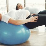 Pregnant women engaging in low-impact exercise with fitness balls indoors.