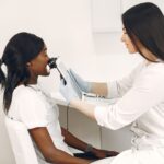 A specialist performing a skin analysis on a patient using advanced equipment in a clinic.