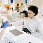 Pregnant woman enjoying a manicure at a salon. Relaxing self-care moment.