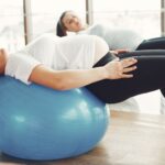 Pregnant women engaging in low-impact exercise with fitness balls indoors.