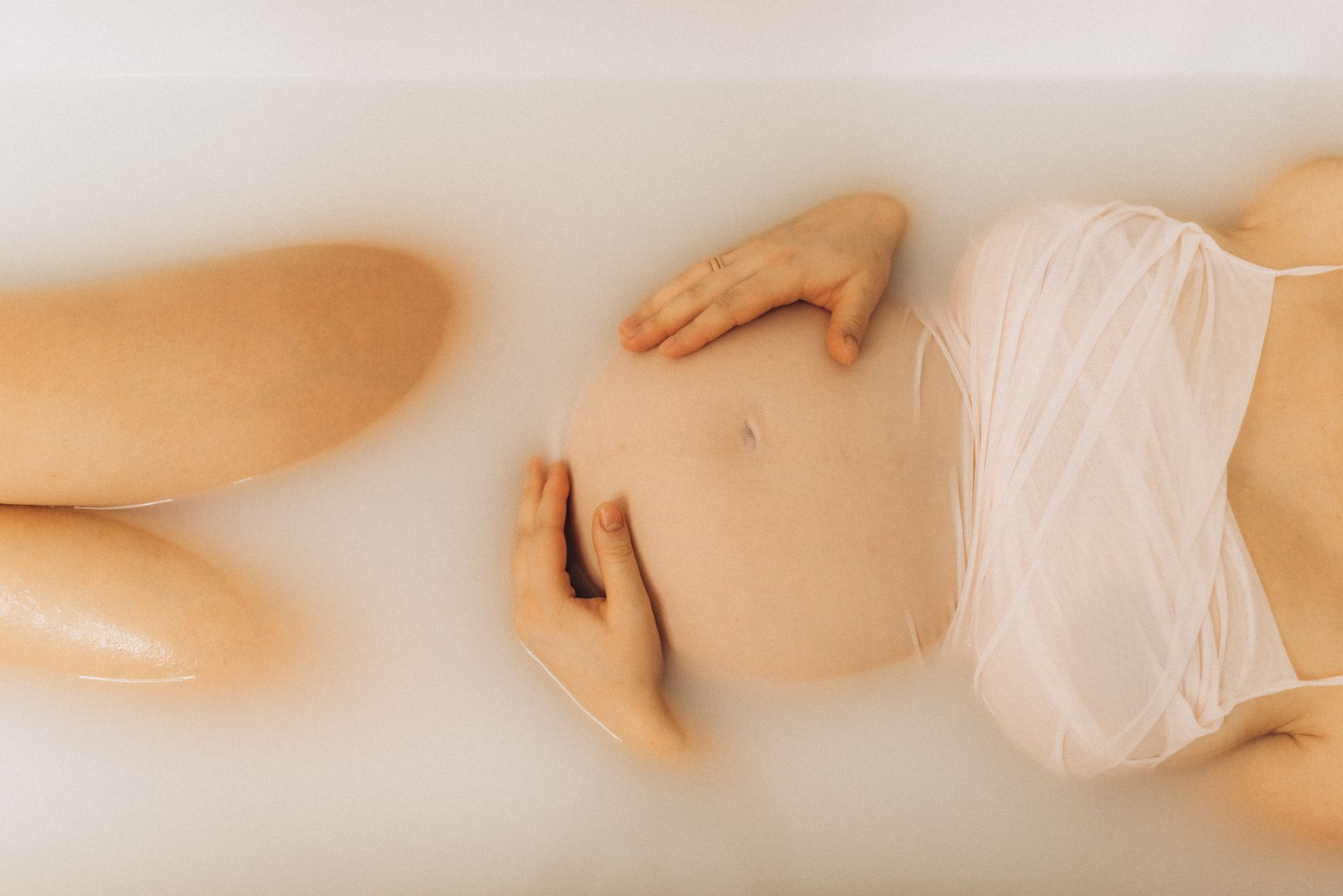 A pregnant woman enjoys a soothing milk bath, embracing maternity and relaxation.