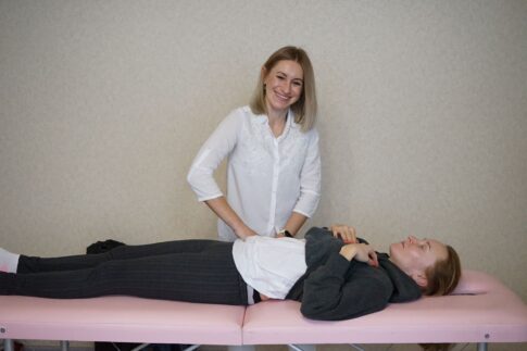 A therapist providing relaxation therapy to a client lying on a massage table indoors.