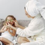 A mother and daughter enjoy a relaxing spa day at home with cucumbers and laughter.