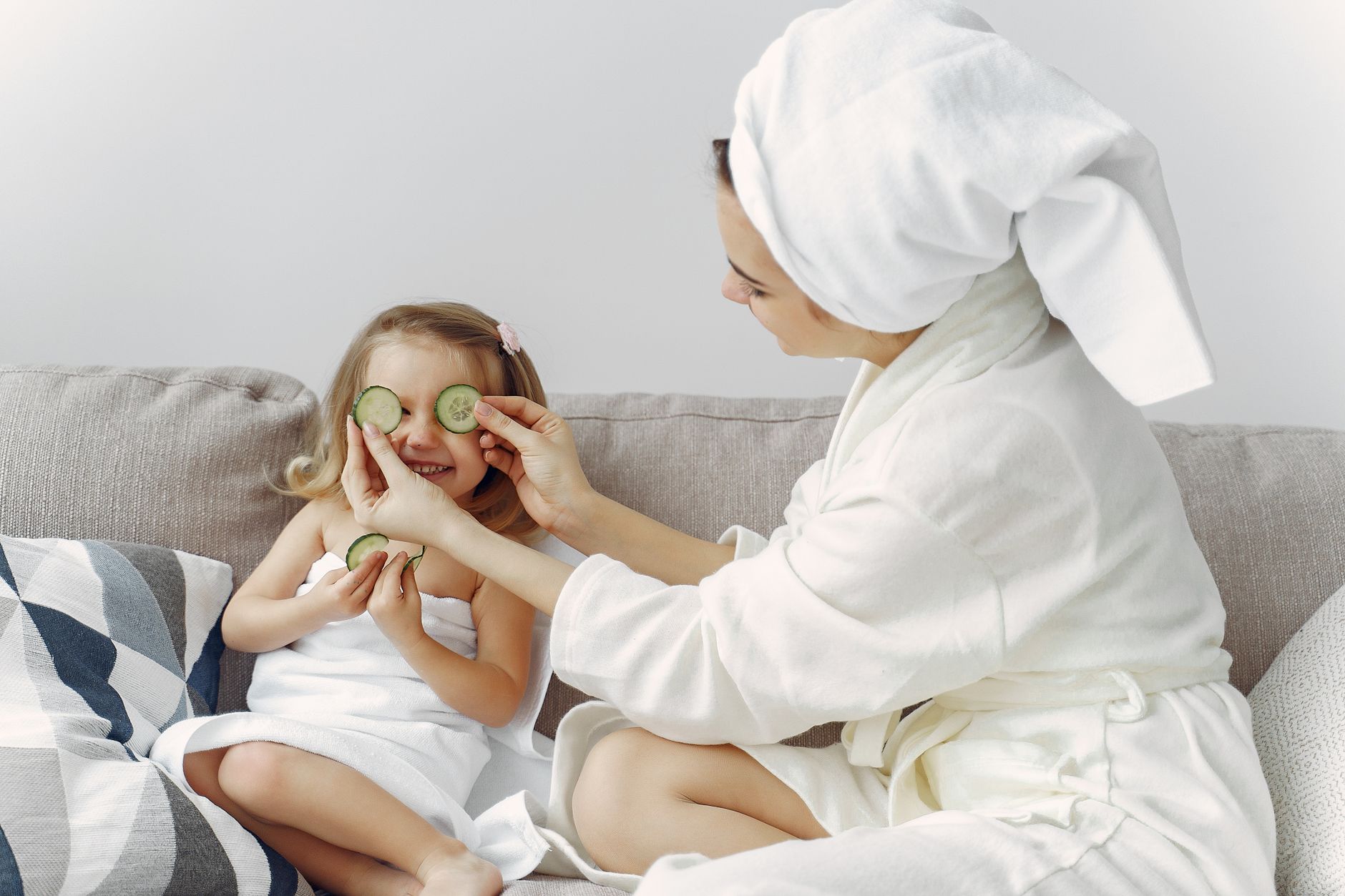 A mother and daughter enjoy a relaxing spa day at home with cucumbers and laughter.
