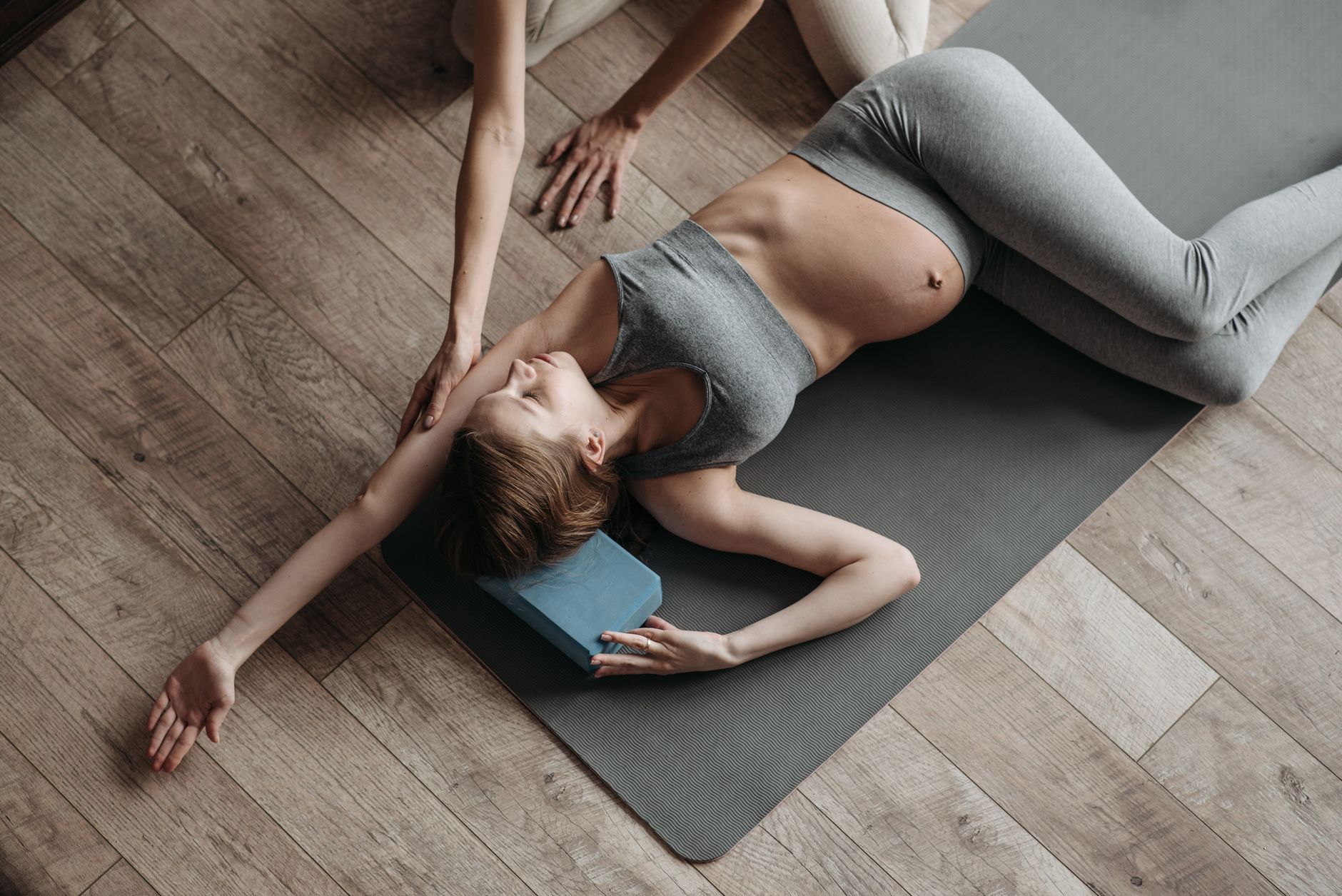 Pregnant woman doing yoga at home with guidance, emphasizing fitness and relaxation.