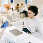 Pregnant woman enjoying a manicure at a salon. Relaxing self-care moment.